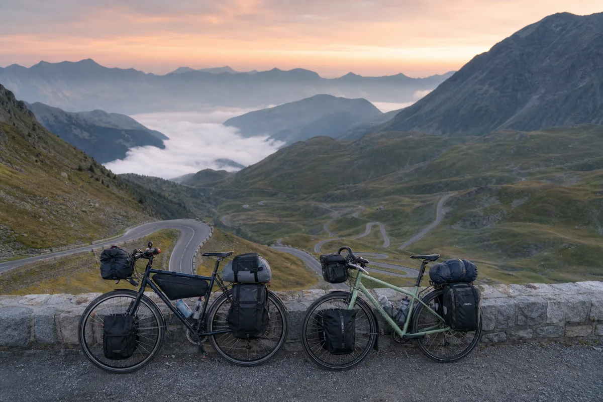 Vélos de randonnée chargés de sacoches sur un col de montagne au lever du jour
